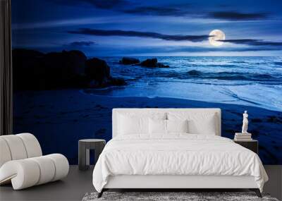 huge stones on the sandy beach at night. wonderful velvet season vacation on the black sea in full moon light. calm waves washing the shore. clouds on the dark blue sky above horizon Wall mural