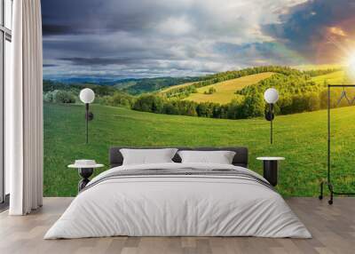 panoramic mountain landscape day and night time change concept. grassy meadow on the hillside. trees on the edge of a hill. mountain ridge in the distance. sun and moon on the sky Wall mural