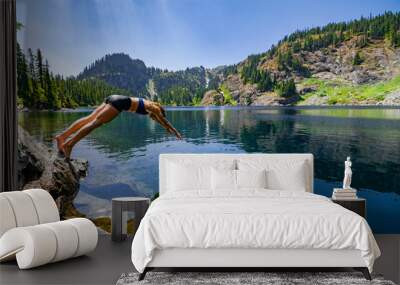 Adventurous athletic female hiker diving into an alpine lake in the Pacific Northwest. Wall mural