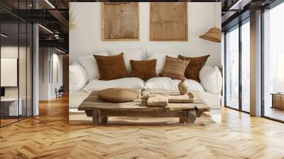 Boho ethnic home interior design. Rustic coffee table and sofa with brown pillows with two poster frames. Wall mural