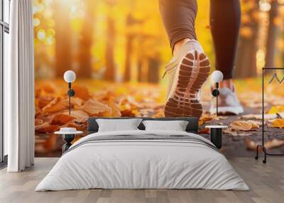 Woman feet in running shoes on autumn park, closeup view. Girl runner walking through forest at sunset. Wall mural