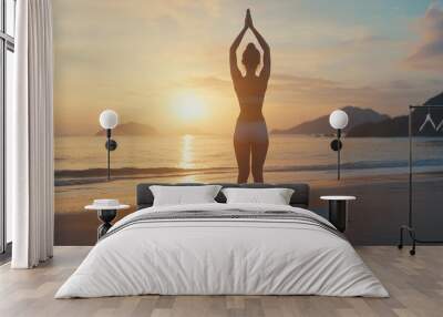 Woman Practicing Yoga on the Beach at Sunset Wall mural