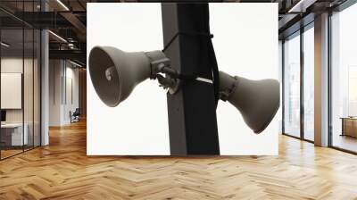 two beige train station speakers pointing in opposite directions fastened to a black rectangular post outside at train station with sky in background Wall mural