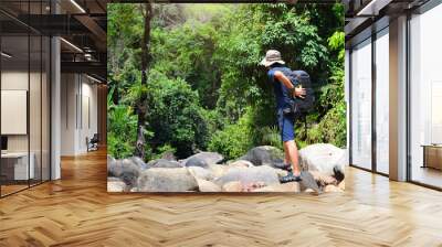 Professional male photographer in forest . Outdoor camping nature hiking forest Wall mural