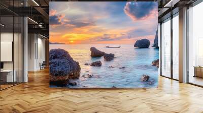 A scenic sunset over a calm tropical bay with a small boat and rocky outcroppings. Wall mural