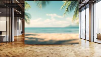 Palm trees frame a blurred view of a tropical beach. Wall mural