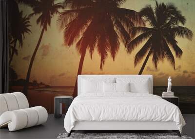 Silhouettes of palm trees on a beach at sunset with a vintage, textured effect. Wall mural