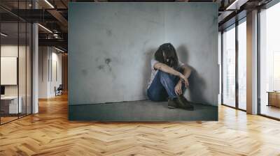 upset girl sitting in the corner of the room Wall mural