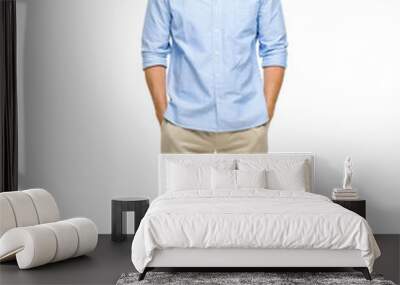 A handsome young man standing alone in the studio with his hands in his pockets isolated on a PNG background. Wall mural