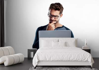 A handsome young man using a laptop and looking confused isolated on a PNG background. Wall mural