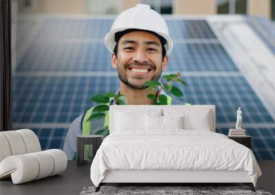 Asian man, portrait and plant with solar panel for eco friendly, environment and sustainable future in city. Engineer, innovation and infrastructure with smile or renewable energy in Malaysia Wall mural