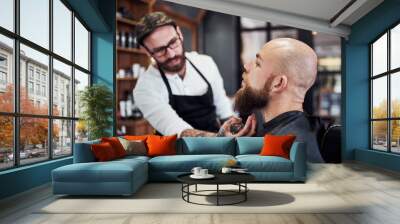 Beard, client and man in barbershop with hair care, cut and tools for trendy facial shave at small business. Style, barber and customer in chair for grooming service, haircut skills and clean trim Wall mural