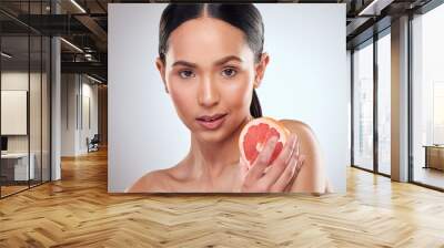 Beauty, diet and grapefruit with portrait of woman in studio on white background for wellness. Aesthetic, fruit and nutrition with face of serious model at spa for cosmetics, dermatology or skincare Wall mural