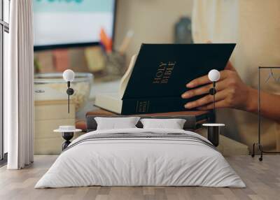 Bible, religion and hands of person reading holy Christian book to worship God for spiritual learning and trust. Faith, knowledge and person with peace due to scripture, praise and gratitude in home Wall mural