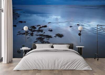 Blue, sand and water on beach at night with calm, peace or zen outdoor for holiday, travel or vacation. Earth, nature and tide with view of ocean or sea in Denmark for climate, journey or trip Wall mural