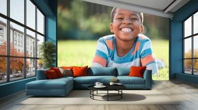 Boy, portrait and big smile in park on grass for summer, development and weekend break in field. Black child, happy and excited in nature for school vacation, relax and fun childhood with sunshine Wall mural