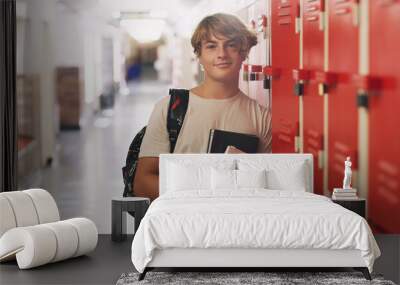 Boy, portrait and hallway as high school student by lockers with books for education, scholarship or campus. Male person, face and learning development with backpack in corridor, academic or study Wall mural