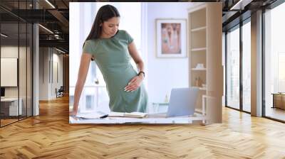 Business, woman and pregnant pain by desk for contractions, muscle ache and tension in lower stomach for hard kick. Mother to be, stress and hand on abdomen for pressure, discomfort and fatigue. Wall mural