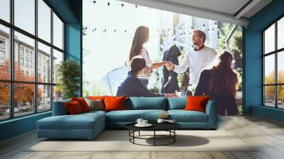 Business people, happy and handshake in meeting at cafe for welcome, b2b networking or collaboration outdoor. Group, employees or shaking hands for onboarding, partnership deal or smile for agreement Wall mural