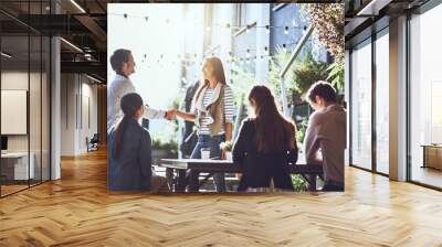 Business people, team and handshake in meeting at coffee shop for welcome, b2b networking or remote work outdoor. Group, employees and shaking hands for onboarding, partnership deal and agreement Wall mural