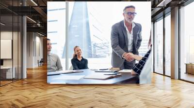 Businessman, meeting and handshake with team for partnership, deal or agreement in conference. Man, CEO or executive shaking hands with employee for hiring, recruiting or b2b together at workplace Wall mural