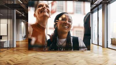 Cafe, window and group of women with smile, bonding and social lunch in city together. Sidewalk, fun and happy girl friends checking menu choice at restaurant for urban brunch on summer weekend. Wall mural