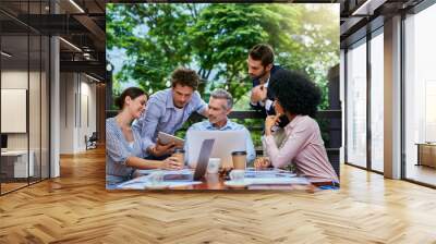 Collaboration, meeting and technology with business people at restaurant for planning outdoor. Documents, laptop and tablet with man and woman employee group at wooden table for teamwork together Wall mural