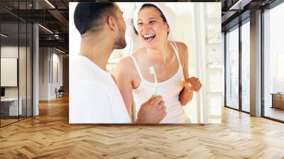 Couple, happy and brushing teeth in bathroom of home for dental hygiene, oral care and laughing for funny man. People, morning routine and toothbrush with comic joke, bonding and grooming in house Wall mural