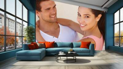 Couple, portrait and happiness with hug by wall for healthy relationship, anniversary date and summer holiday. Support, man and woman with embrace, smile and affection for trust, comfort and care Wall mural