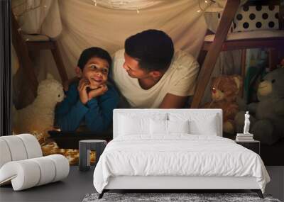 Dad and son at night on tablet in tent watching movies, online games and cartoon with fairy lights. Happy family, blanket and father with boy in bedroom on digital tech for bonding, relax and love Wall mural