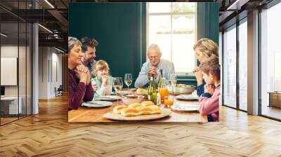 Family, hands and prayer with wine, feast and gathering with thanksgiving celebration. People, dinner and praise with religion, lunch and bonding with retirement and holiday or vacation reunion Wall mural