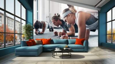 Fitness, personal trainer and plank exercise with group, healthy workout or training in gym for weight loss. Athlete, man and women together for power challenge, strong muscle at club or commitment Wall mural