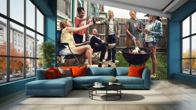 Friends, cheers and beer in backyard with bbq for social event, party or celebration with talking in home. People, drinking alcohol and toast with relax, conversation or diversity at barbecue reunion Wall mural