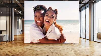 Friends, funny and hug with women on beach together for holiday, travel or vacation in summer. Love, smile or trust with happy people embracing and laughing outdoor at ocean or sea for bonding Wall mural