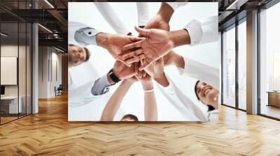 Hands stack, medical and people at hospital for healthcare support, solidarity and teamwork of workforce motivation. Staff, diversity and collaboration, trust and synergy together for low angle Wall mural