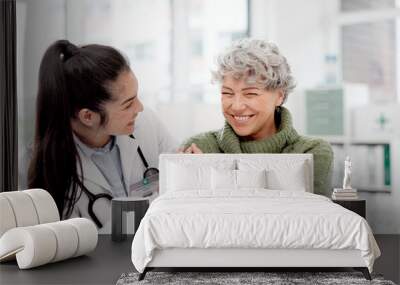 Happy, care and face of a doctor with a woman for medical trust, healthcare and help. Laughing, hug and portrait of a young nurse with a senior patient and love during a consultation at a clinic Wall mural