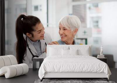 Happy, hug and face of a doctor with a woman for medical trust, healthcare and help. Laughing, care and portrait of a young nurse with a senior patient and love during a consultation at a clinic Wall mural