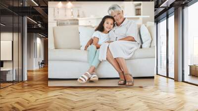 Happy, relax and portrait of child with grandmother on sofa for bonding, connection or care in home. Smile, love and girl kid resting with senior woman in living room of family house in Mexico. Wall mural