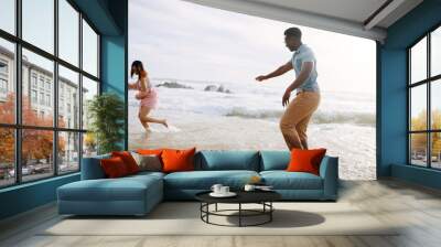 Happy, sand and couple running at the beach for holiday and summer vacation with travel by ocean. Hawaii, fun and tropical with sea water and people on an island with freedom and sunshine outdoor Wall mural