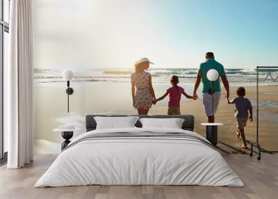 Happy family, walking and holding hands at beach in summer for relax, travel and holiday in Miami. Children, parents and people at ocean with back for vacation, trust and bonding together by water Wall mural