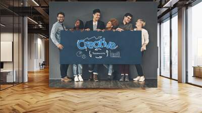 Happy people, creative and team with poster for startup, banner or business together on gray wall background. Group of young employees with smile, sign or billboard for presentation, graph or chart Wall mural