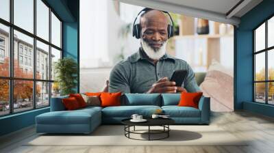 Home, headphones and senior man with smartphone, typing and social media with internet, connection and sound. Good news, pensioner and mature person with headset, cellphone and mobile user with radio Wall mural