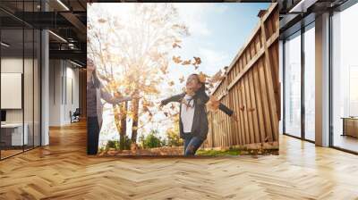 Kids, mother and girl throwing autumn leaves in garden of home together for bonding or love. Asian family, fall or smile with happy single parent and daughter having fun in backyard for wellness Wall mural