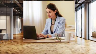 Laptop, serious and business woman typing in office for research, creative blog and copywriting. Computer, mature manager and writing email, feedback or review report for content writer at startup Wall mural