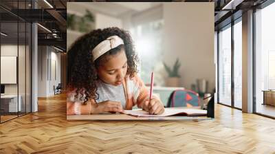 Little girl, student and writing with book in kitchen for homework or assessment at home. Young female person, child or kid taking notes or studying with stationery for learning or education at house Wall mural