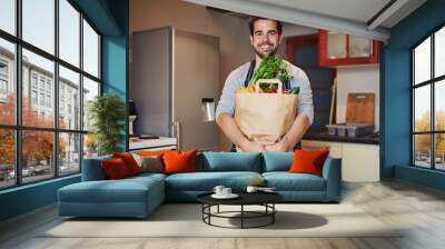 Man, portrait and paper bag with vegetables for health, nutrition or vegan diet for wellness. Male person, groceries and smile in kitchen for cooking with food and shopping to prepare dinner or lunch Wall mural