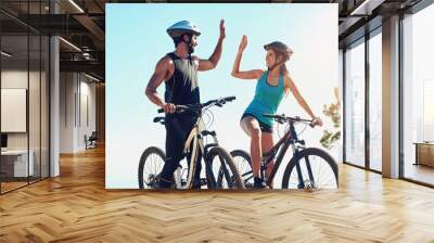 Man, woman or together on bicycle with high five in countryside for exercise, celebrate for workout goal. Team, people or bike with hands for training success on mountain, healthy motivation in sport Wall mural