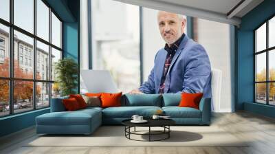 Mature, investor and portrait of professional businessman in England as broker for asset management with laptop. Happy, entrepreneur and investment in city, office for development of property or deal Wall mural