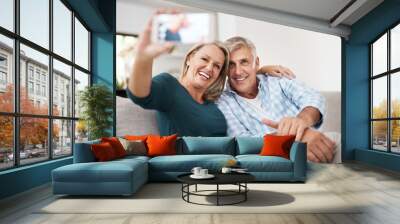 Mature couple, people and home on sofa for selfie with smile for bonding, love and memories. Relationship, care and happy in living room on couch for fun, enjoy and relax for social media post Wall mural