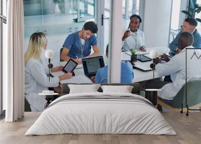 Medical, group and meeting for healthcare in conference room with technology, top view and discussion. Collaboration, doctor and nurse team in boardroom for surgery brainstorming and health planning Wall mural